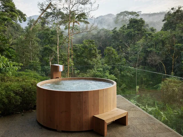 Cedar cold plunge tub on a stone terrace above the Bali jungle